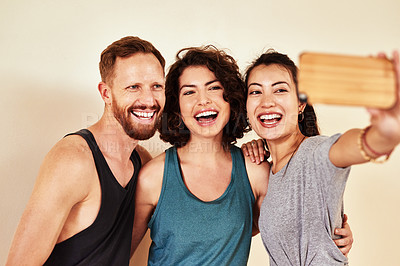 Buy stock photo Shot of a group of young men and women taking selfies in yoga class 