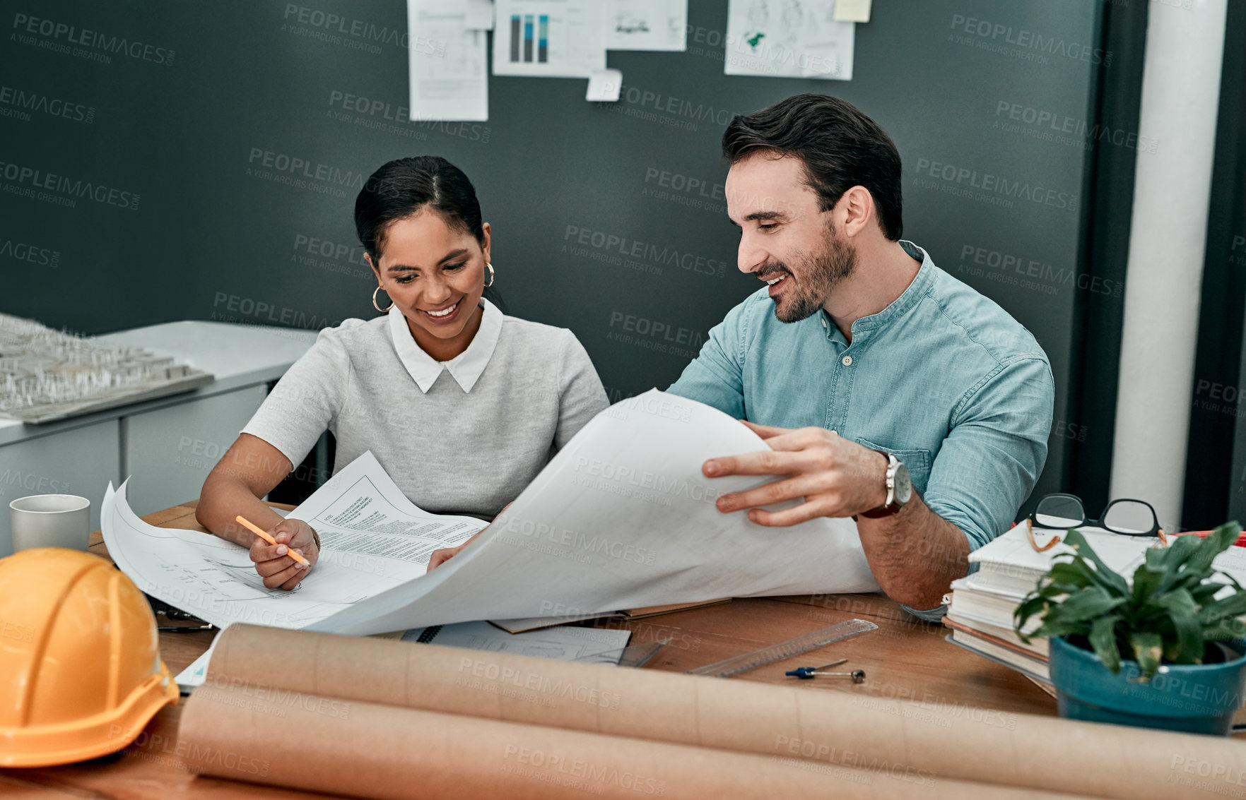 Buy stock photo Shot of two architects working with blueprints in an office