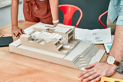 Buy stock photo Closeup shot of two architects working together on a scale model of a building in an office
