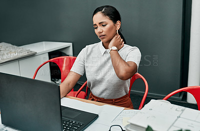 Buy stock photo Shot of a young businesswoman suffering with neck pain while working in an office