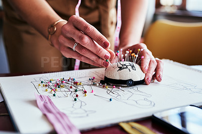 Buy stock photo cropped shot of an unrecognizable designer using a pincushion while working in her workshop