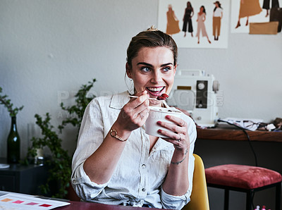 Buy stock photo Cropped shot of a fashion designer having breakfast while sitting at her desk