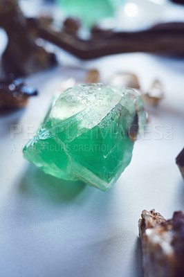 Buy stock photo Closeup of a beautiful green crystal placed on a table with other different types of crystals inside during the day