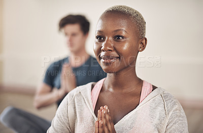 Buy stock photo Cropped shot of an attractive young woman sitting and meditating after a yoga class indoors