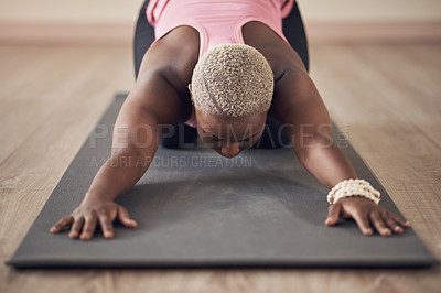 Buy stock photo Cropped shot of an unrecognizable woman holding a child's pose during an indoor yoga session alone