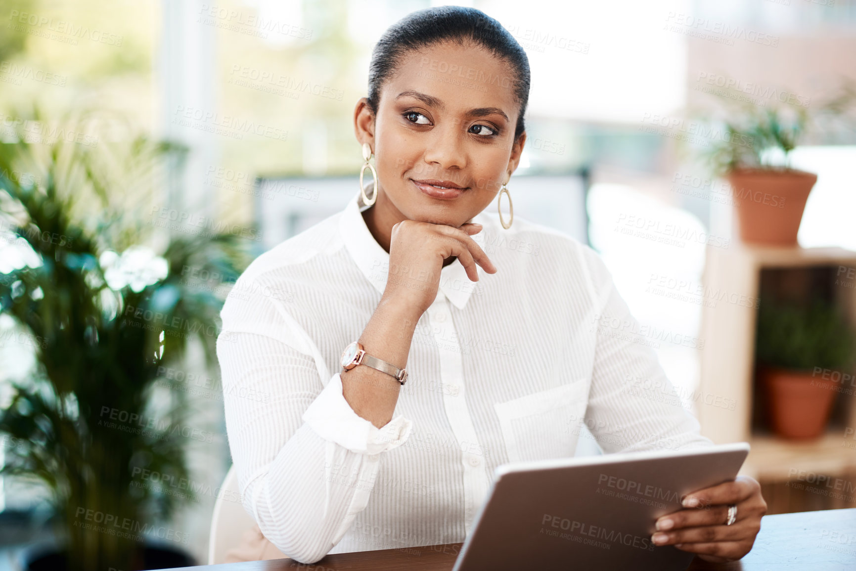Buy stock photo Shot of a young businesswoman using a digital tablet in a modern office
