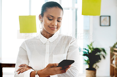 Buy stock photo Shot of a young businesswoman using a smartphone while having a brainstorming session in a modern office