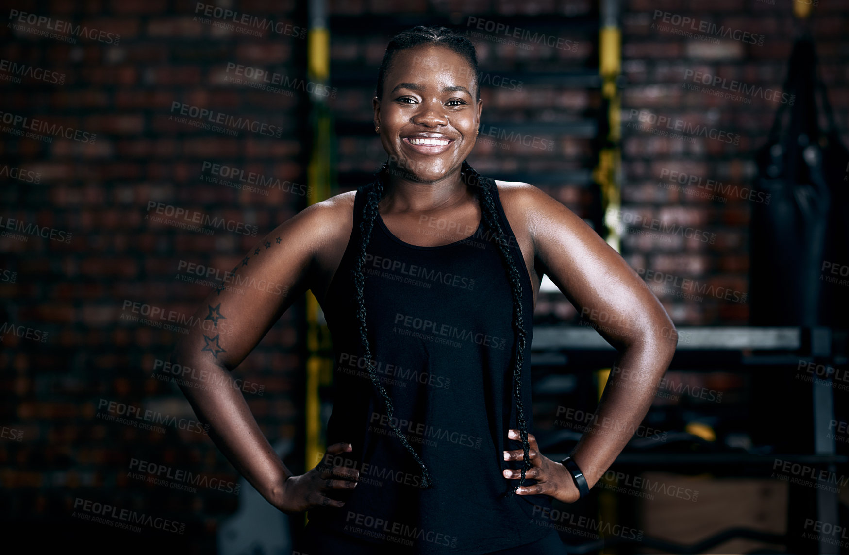 Buy stock photo Cropped portrait of an attractive young female athlete standing with her hands on her hips in the gym