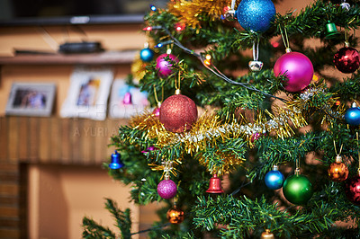 Buy stock photo Cropped shot of a Christmas tree full of decorations inside of a house during Christmas time