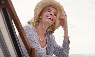 Buy stock photo Cropped shot of an attractive senior woman relaxing on a lounger on a summer's day at the beach