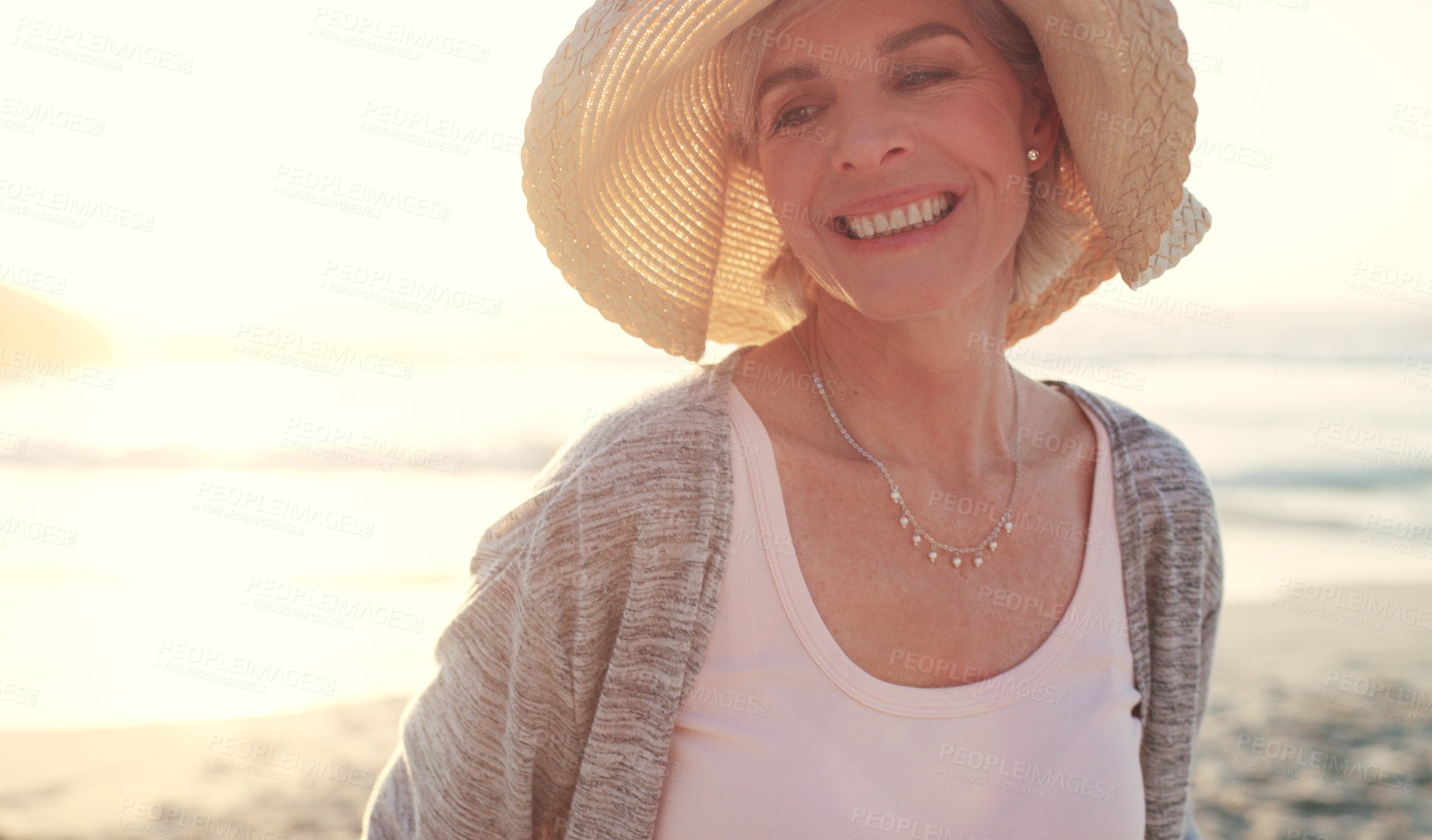 Buy stock photo Cropped shot of an attractive senior woman enjoying the beach at sunset