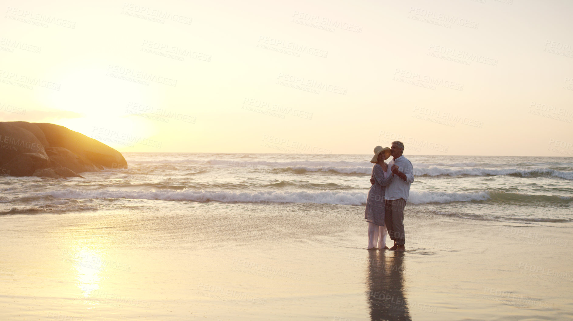 Buy stock photo Full length shot of an affectionate senior couple dancing together at the beach at sunset