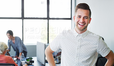 Buy stock photo Portrait of a confident young businessman working in a modern office with his colleagues in the background