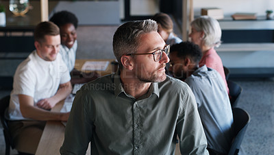 Buy stock photo Shot of a confident mature businessman in in the office boardroom with his colleagues in the background