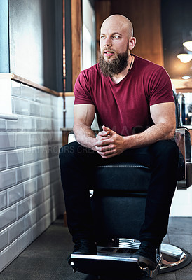 Buy stock photo Full length shot of a handsome young barber sitting on a chair inside his barbershop