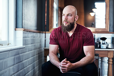 Buy stock photo Cropped shot of handsome young barber sitting on a chair inside his barbershop