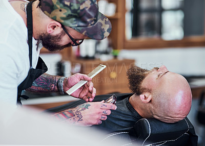 Buy stock photo Cropped shot of a handsome young man getting his beard trimmed and lined up at a barbershop