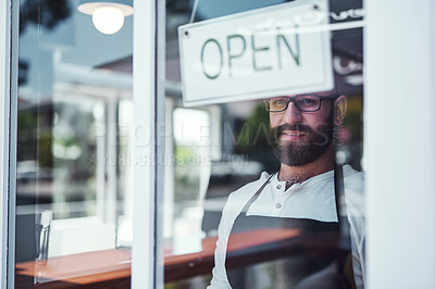 Buy stock photo Cropped shot of a handsome young barber hanging up an open  sign on the window of his barbershop