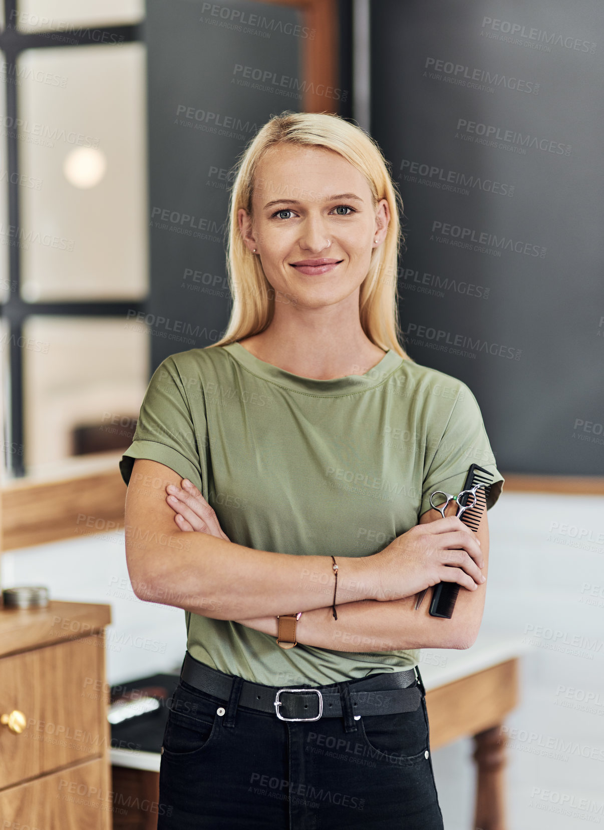 Buy stock photo Portrait of an attractive young hairdresser posing with her arms folded inside her salon