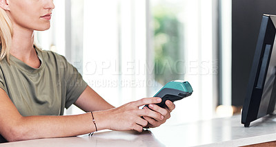 Buy stock photo Cropped shot of an unrecognizable hairdresser using a card machine inside her salon