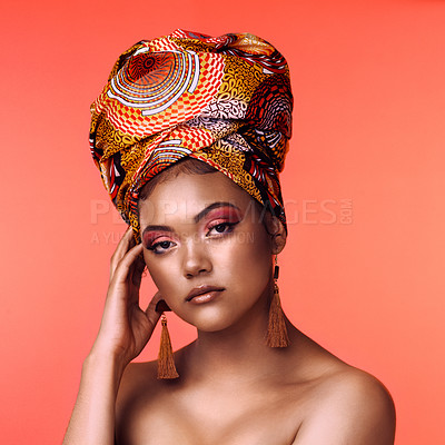 Buy stock photo Studio shot of an attractive young woman wearing a traditional  African head wrap posing against an orange background