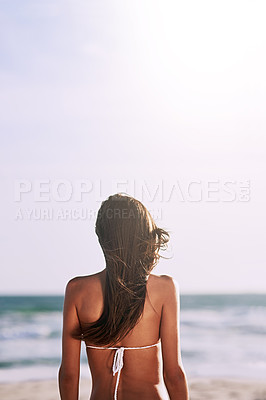 Buy stock photo Rearview shot of an unrecognizable young woman at the beach