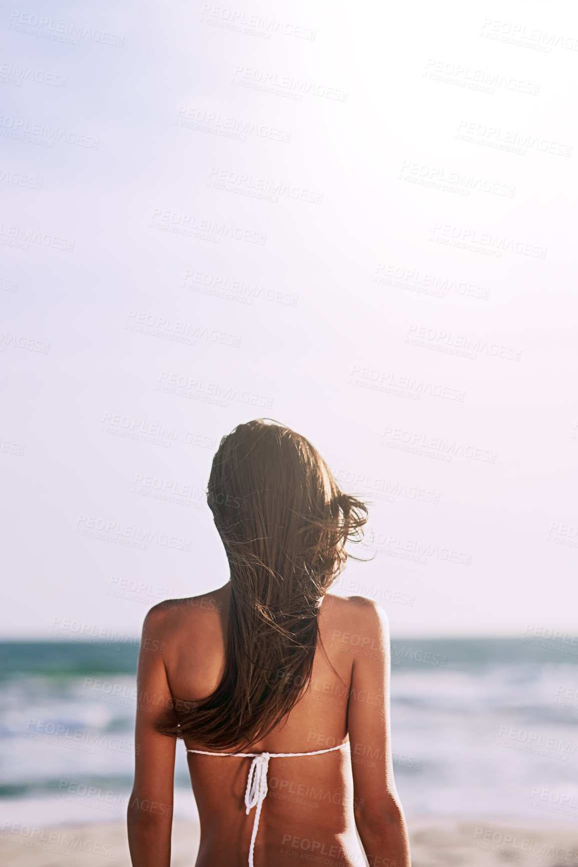 Buy stock photo Rearview shot of an unrecognizable young woman at the beach