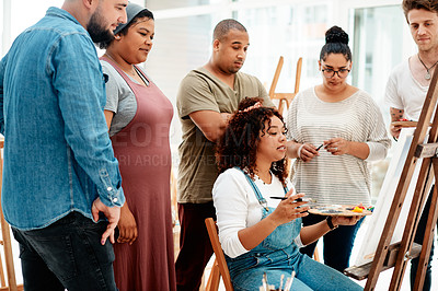 Buy stock photo Cropped shot of an attractive young woman sitting and explaining her artwork to her friends during an art class