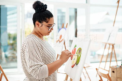Buy stock photo Cropped shot of an attractive young artist standing alone and painting during an art class in the studio