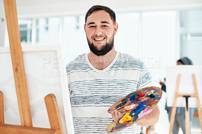Buy stock photo Cropped portrait of a handsome young artist standing alone and painting during an art class in the studio