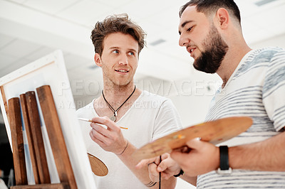 Buy stock photo Cropped shot of a handsome young man standing with his friend and painting during an art class in the studio