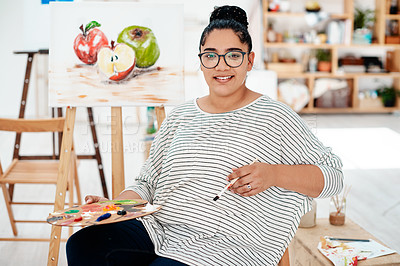 Buy stock photo Cropped portrait of an attractive young artist sitting alone in the studio and holding a palette during an art class