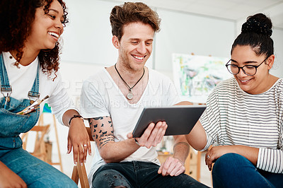 Buy stock photo Cropped shot of a diverse group of friends sitting together and using a tablet during an art class