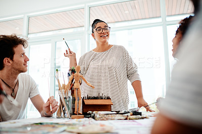 Buy stock photo Cropped shot of an attractive young artist standing and talking to her friends during an art session in the studio