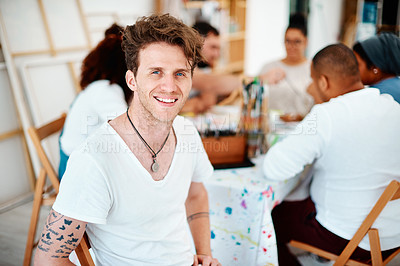 Buy stock photo Cropped portrait of a handsome young man sitting with his friends during an art class in the studio