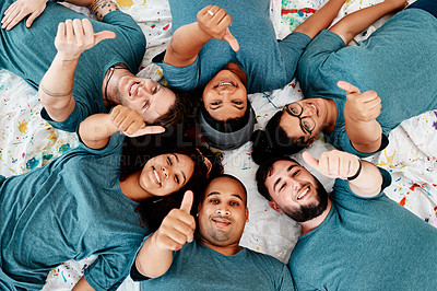 Buy stock photo Cropped portrait of a diverse group of friends lying down and showing a thumbs up after an art class