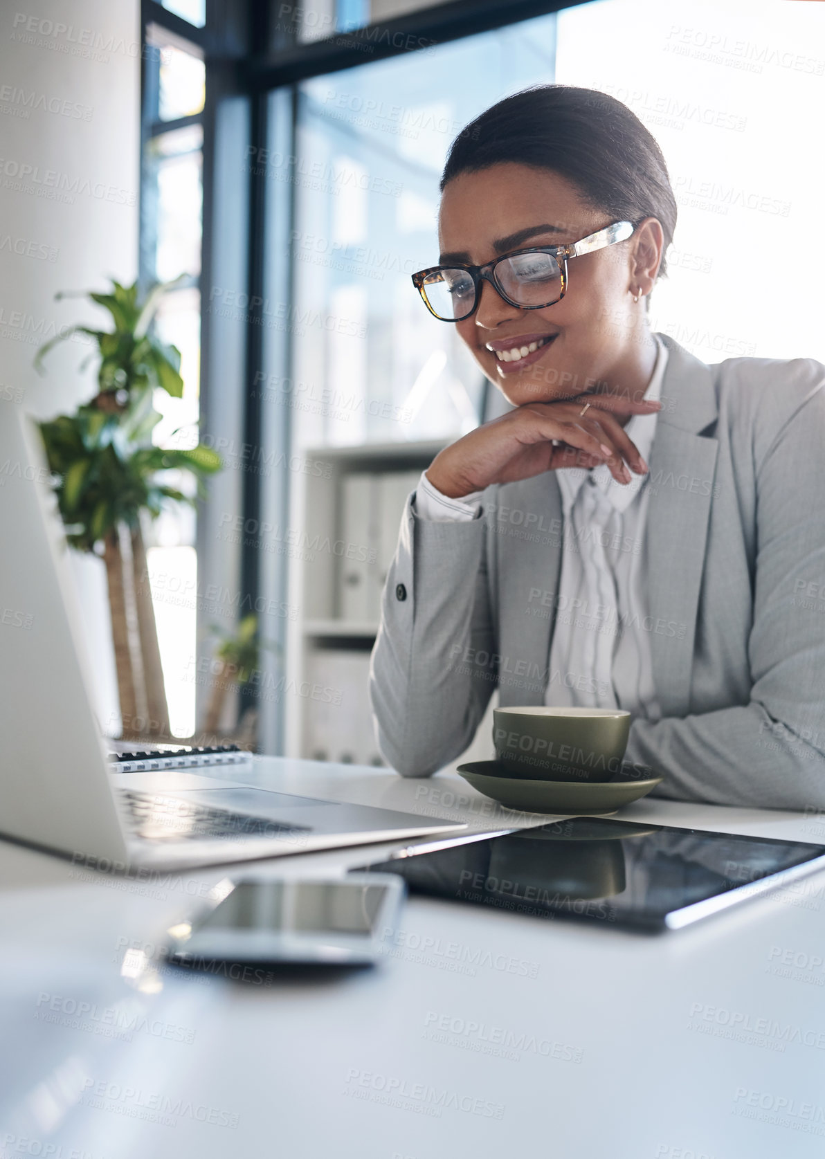 Buy stock photo Cropped shot of an attractive young businesswoman working on a laptop inside her office