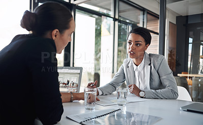 Buy stock photo Cropped shot of two attractive young businesswomen working together inside a modern office