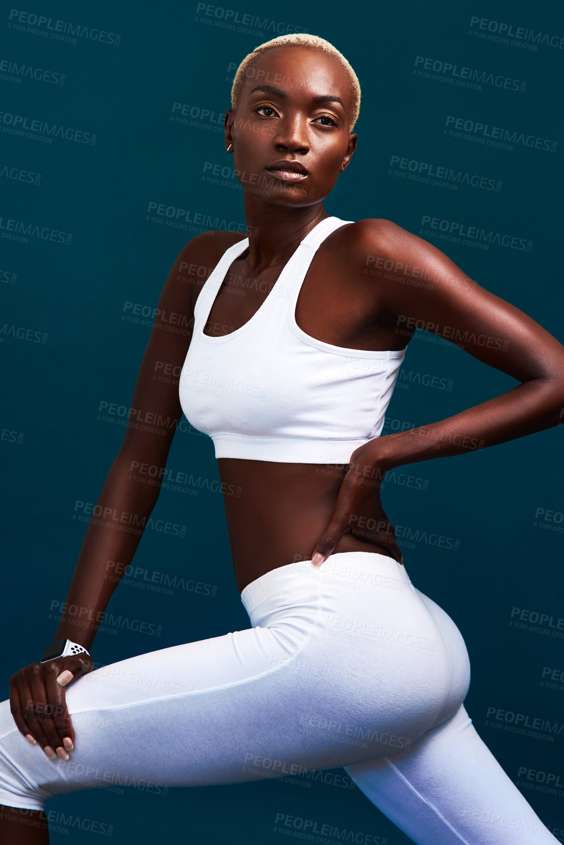 Buy stock photo Cropped shot of an attractive young sportswoman stretching against a dark background in the studio