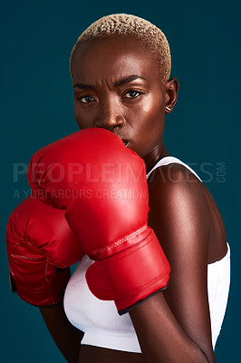 Buy stock photo Cropped portrait of an attractive young female boxer working out against a dark background in the studio