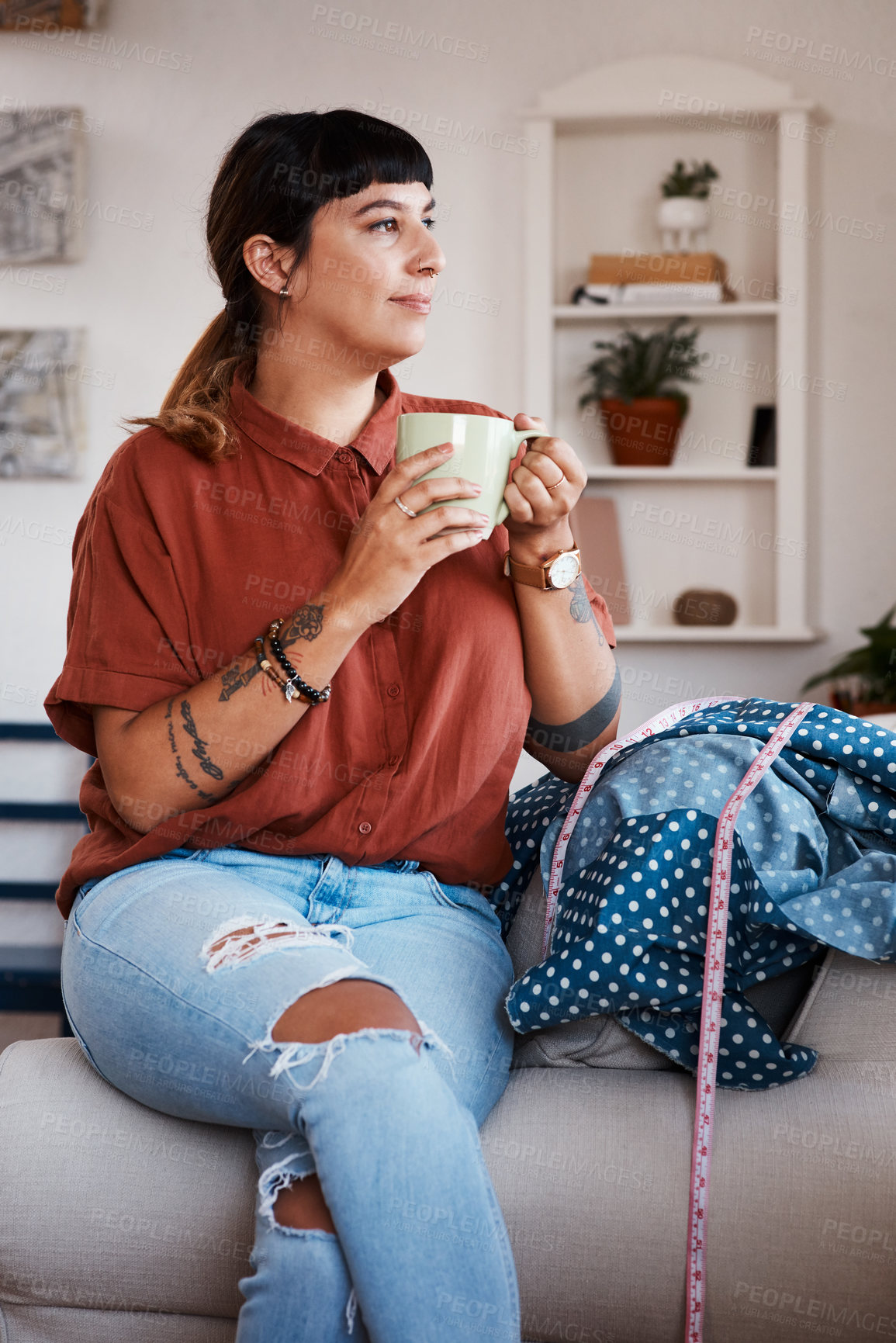 Buy stock photo Shot of a clothing designer taking a break from her work with a cup of coffee