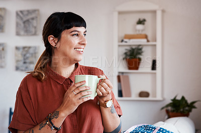 Buy stock photo Shot of a young woman enjoying a cup of coffee while relaxing at home