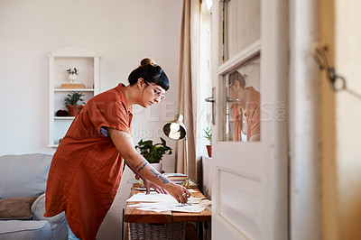 Buy stock photo Shot of a an artist looking at her sketches on a desk at home