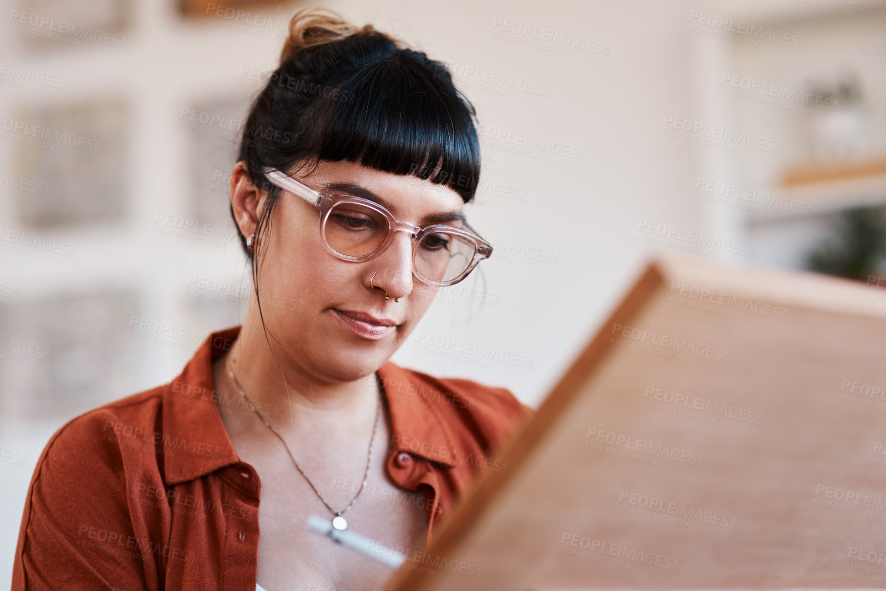 Buy stock photo Shot of an artist sketching in a easel at home