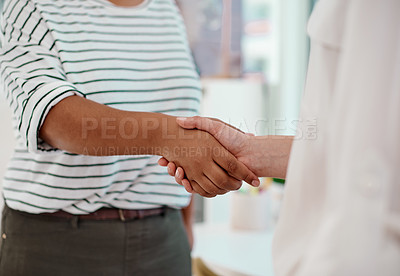 Buy stock photo Cropped shot of two unrecognizable businesswomen shaking hands together inside an office