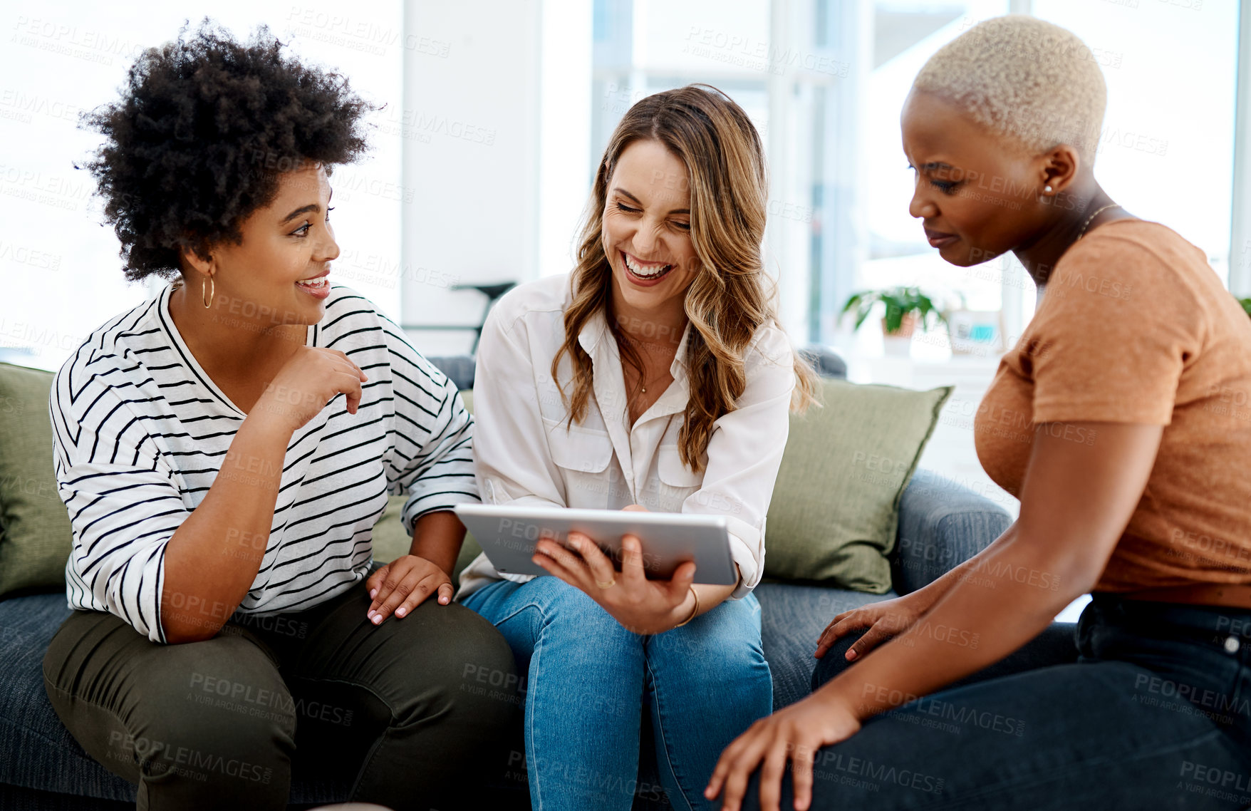 Buy stock photo Shot of a group of businesswomen working together on a digital tablet in an office