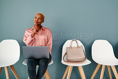 Buy stock photo Studio shot of an attractive young businesswoman looking thoughtful while using a laptop against a grey background