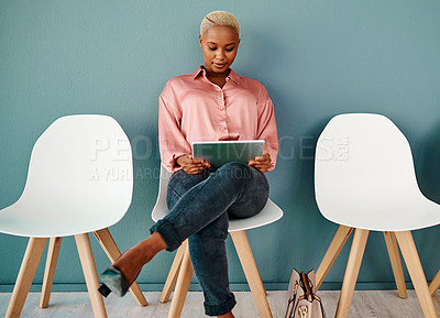Buy stock photo Studio shot of an attractive young businesswoman using a digital tablet while sitting in line against a grey background