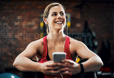 Buy stock photo Cropped shot of an attractive young female listening to music while working out in the gym