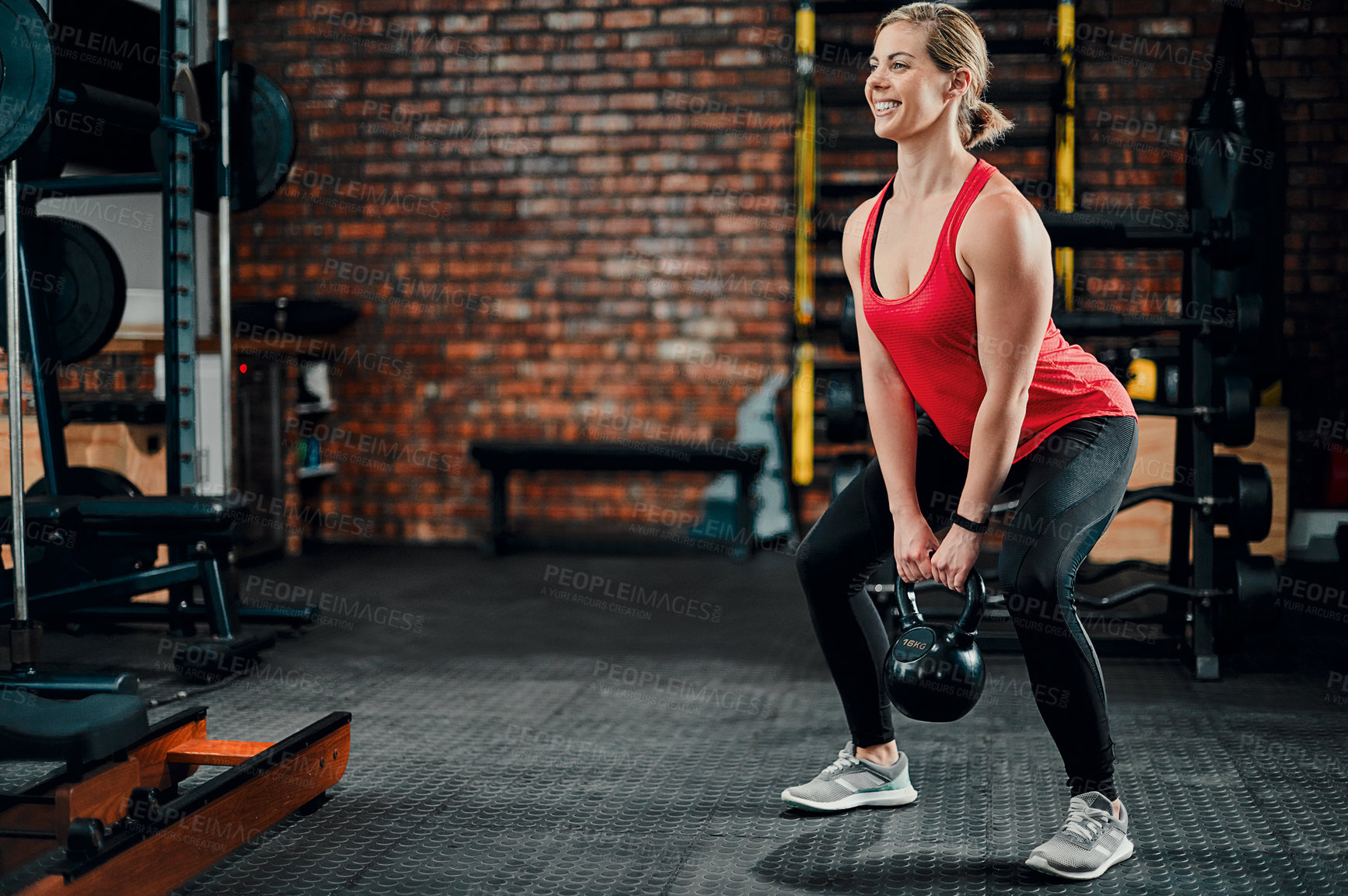 Buy stock photo Full length shot of an attractive young female athlete working out with a kettle bell in the gym